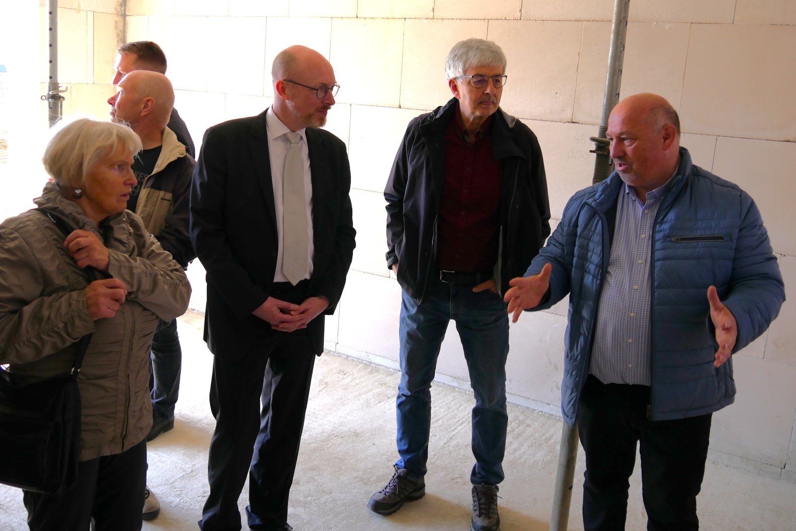 ein Person redet mit anderen Personen auf der Baustelle